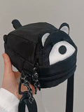Black raccoon crossbody phone bag held in hand, face and ears on the lid