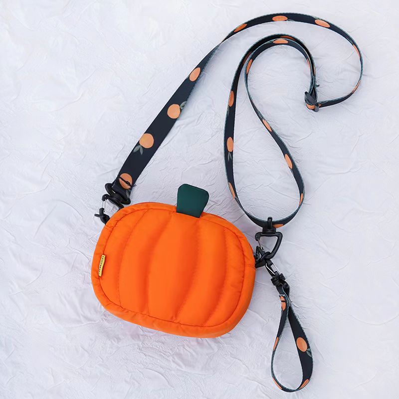 Orange quilted pumpkin crossbody bag with orange-print strap, front view