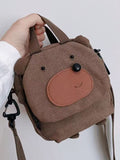 Brown bear canvas crossbody bag held by its top handles, front view