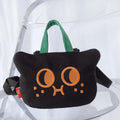 Black cat face crossbody phone bag with orange embroidered eyes and green handles, front view