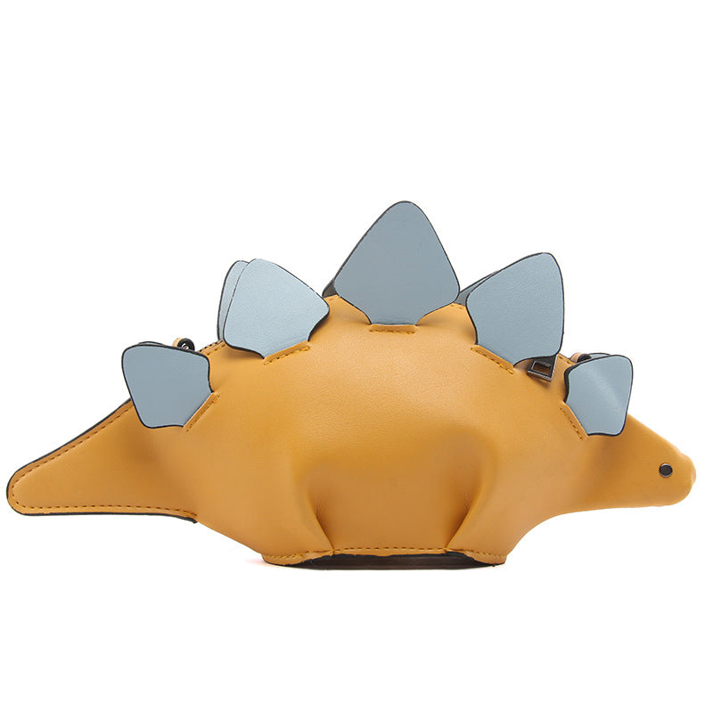 Mustard yellow stegosaurus crossbody bag with blue-grey back plates, side view