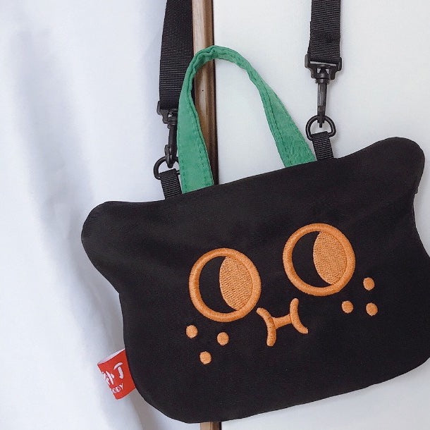 Cat bag hanging by its detachable crossbody strap