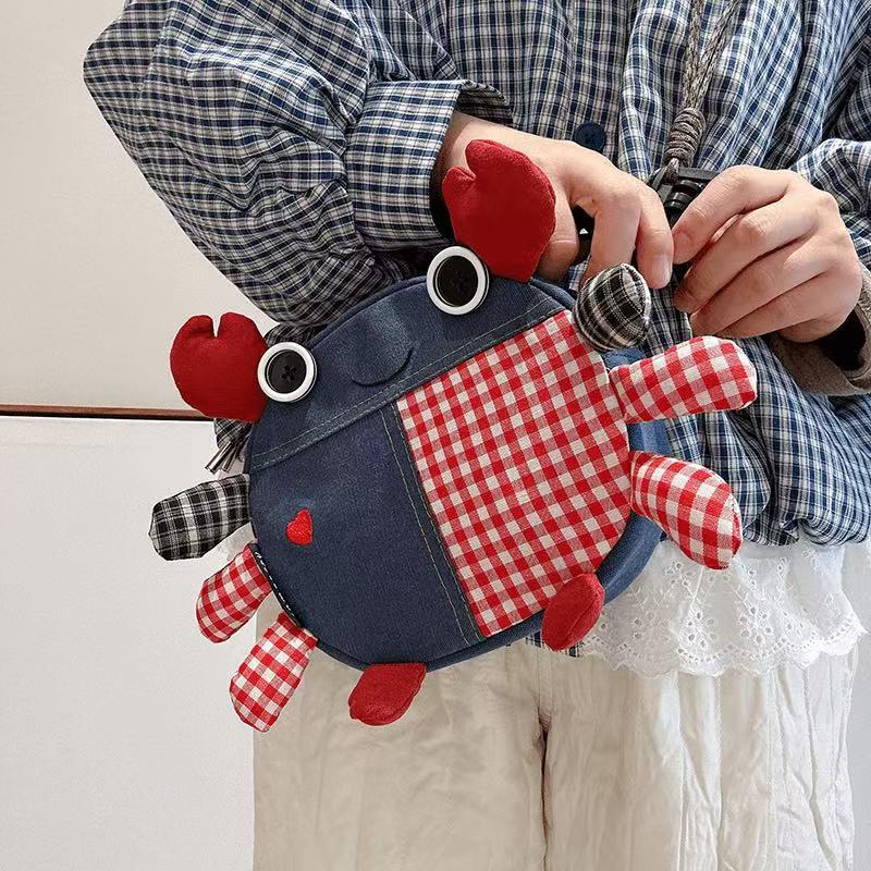 Denim and gingham crab bag held in both hands, front view