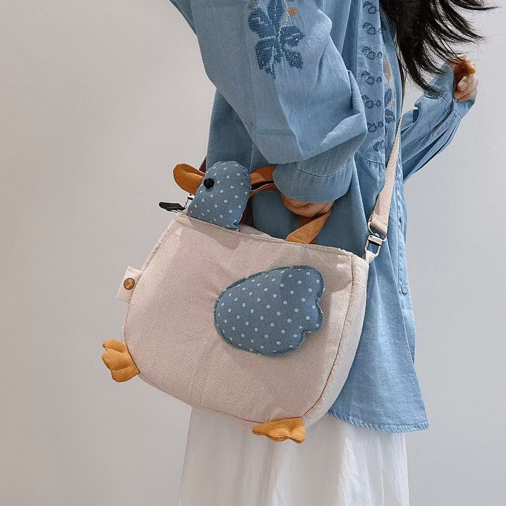 Oat pinstripe duck crossbody bag with padded wing and corduroy feet