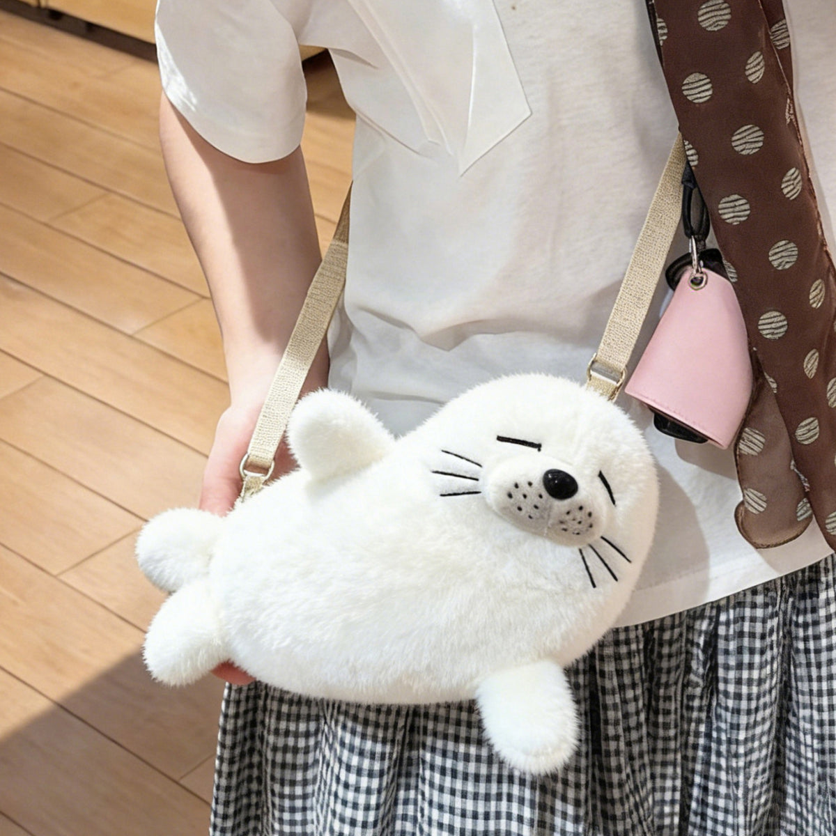 Cream white seal plush bag worn crossbody at the hip