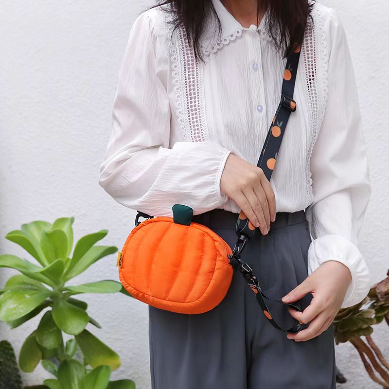 Pumpkin bag worn crossbody at the hip with a white blouse