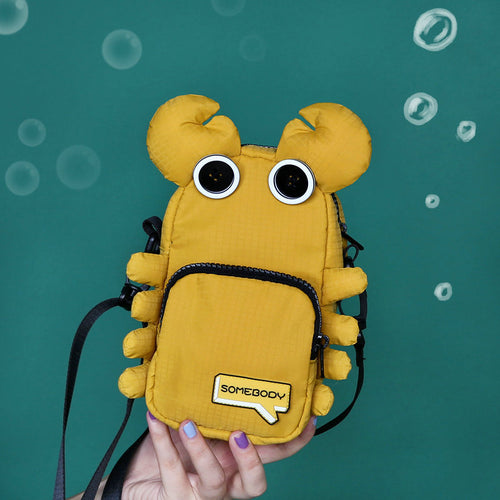 Mustard yellow crab crossbody bag held in hand