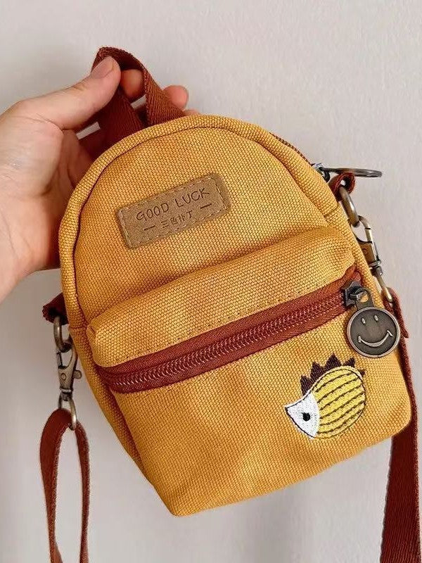 Front close-up of the canvas bag showing the embroidered hedgehog and front zip pocket