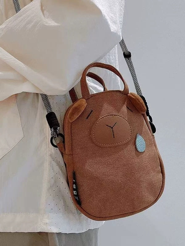 Close-up of the capybara bag's stitched snout, plush ears and rope strap