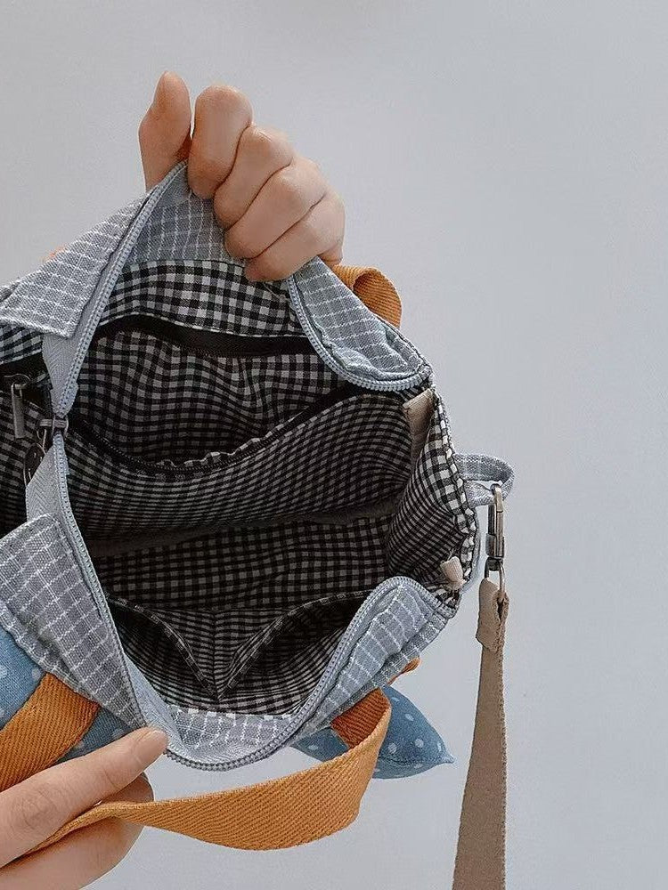 Duck bag held open showing zip top, gingham lining and inner pockets