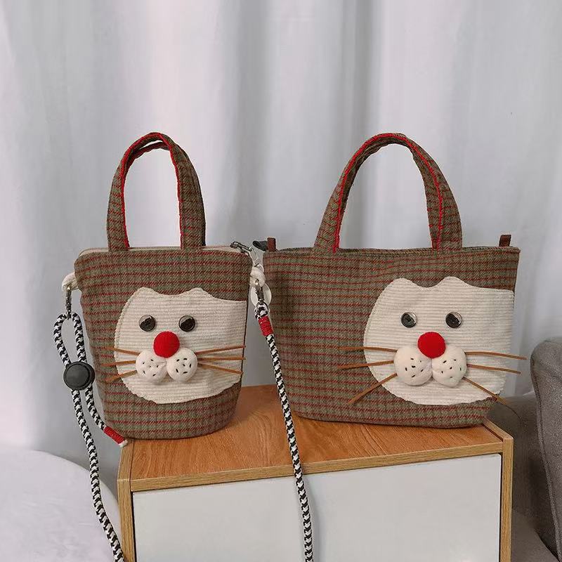 Mini crossbody and tote versions of the red nose cat bag side by side