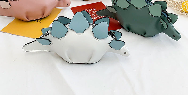 White stegosaurus bag with blue plates next to a teal one