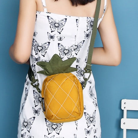 Pineapple mini bag worn crossbody over a white dress