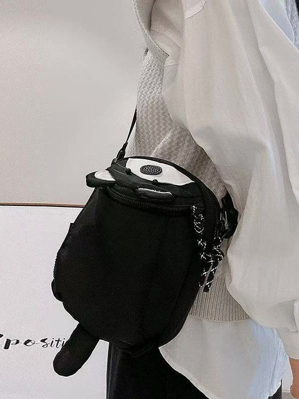 Black raccoon bag worn at the hip, side view of body and tail