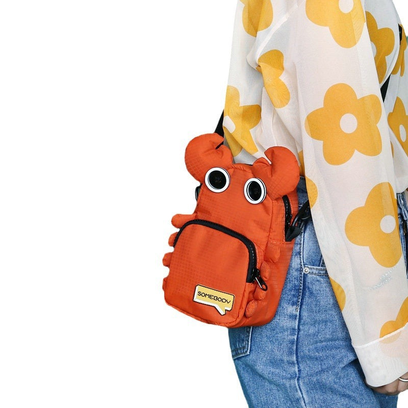 Orange crab bag worn crossbody with jeans