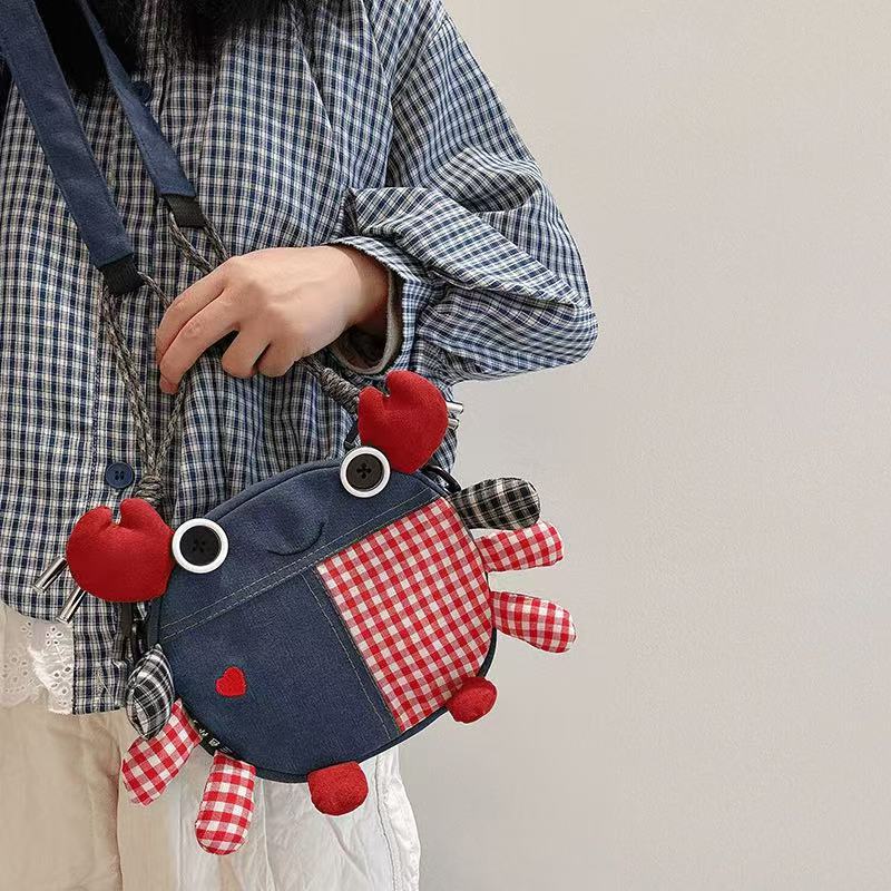 Heart crab denim bag worn crossbody over a checked shirt