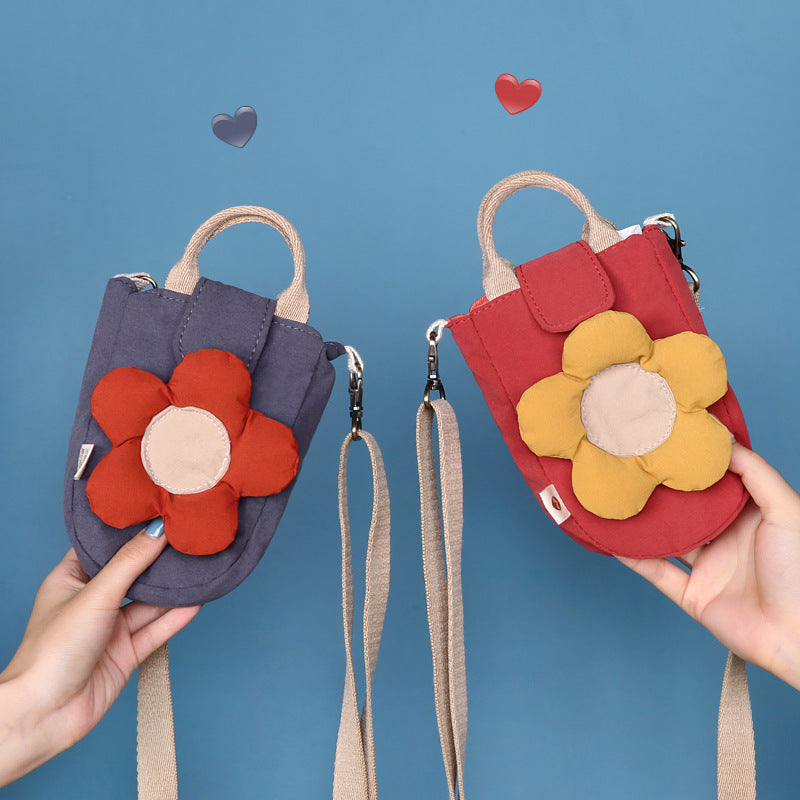Grey and red puffy flower phone bags held up against a blue background