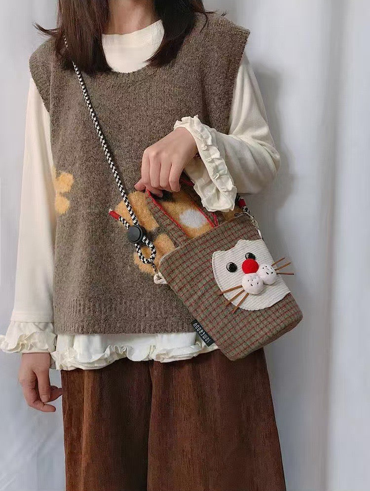 Red nose cat mini crossbody bag worn on its rope strap