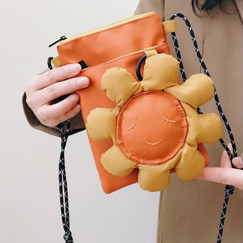 Orange sunflower phone bag held in hand, close-up of the flower