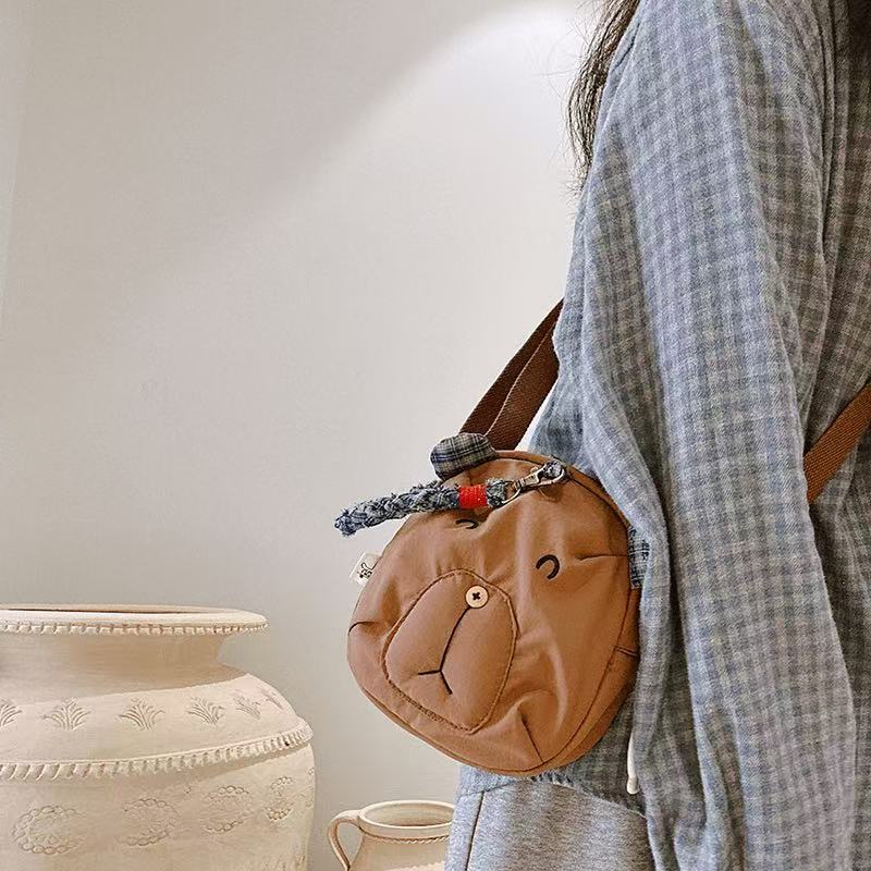 Brown bear crossbody bag with button nose worn at the hip