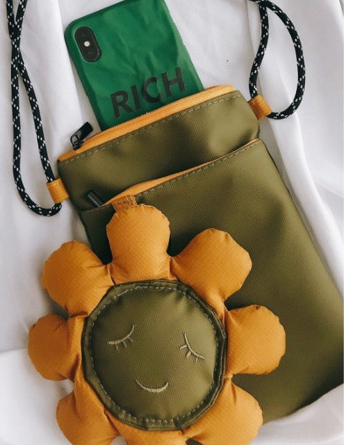Phone tucked into the main pocket of the olive green bag