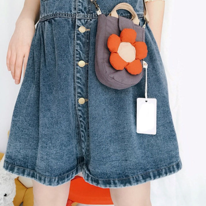 Grey flower phone bag worn crossbody over a denim dress