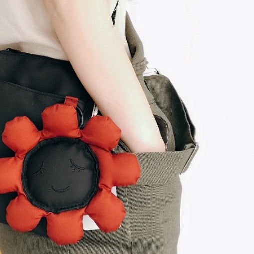 Black sunflower phone bag worn at the hip, close-up